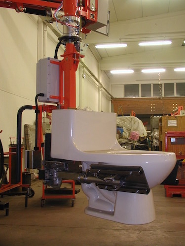 Průmyslové manipulátory pro manipulaci se sanitarní techniikou a keramickými výrobky<br>Přemístěníí záchodu pomocí úchopu speciálních kleští