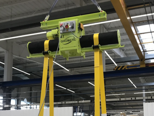 Traverza pre otáčanie bremien s nastaviteľnou roztečou kladiek<br>Otočnú časť tvorí valec s protišmykovou vrstvou, ktorá je poháňaná elektromotorom cez remenicu. Rozteč pásov je možné upraviť podľa dĺžky bremena. Pásy sú vybavené ochrannou. Traverza je ovládaná pomocou rádiového ovládania.